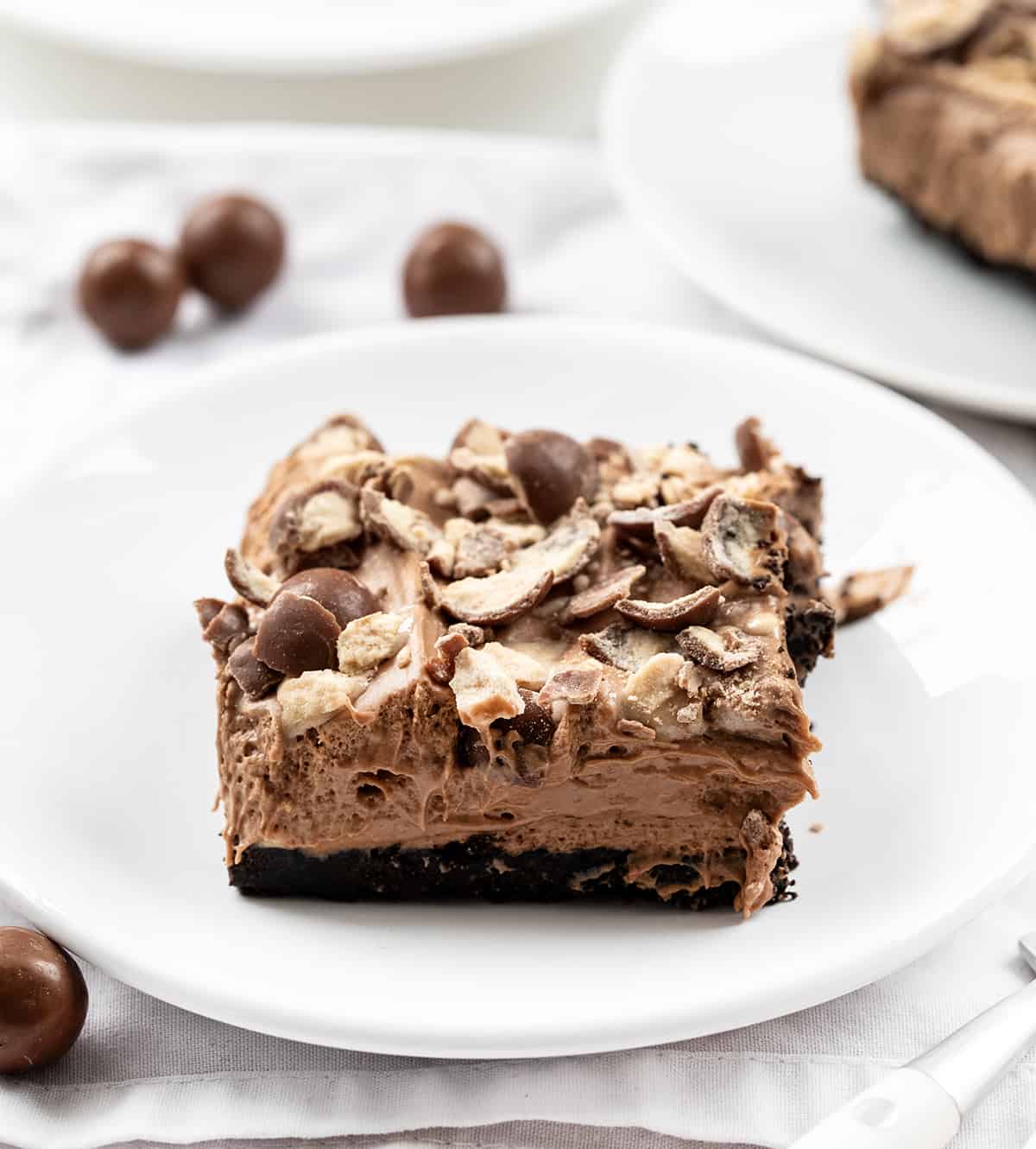 Plates of Chocolate Malt Shoppe Bars with Whoppers Around.